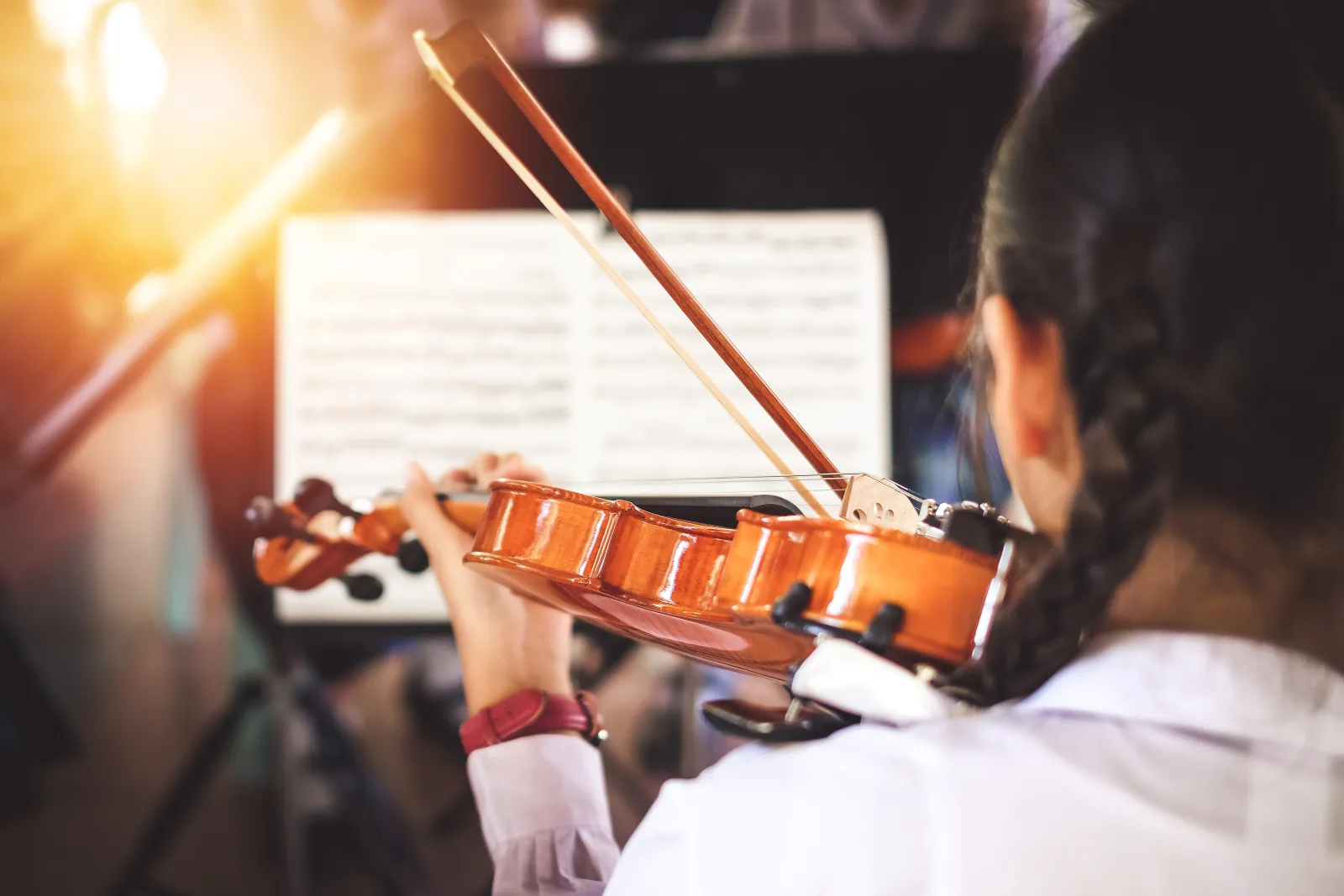 A student playing violin from a music stand in a group class